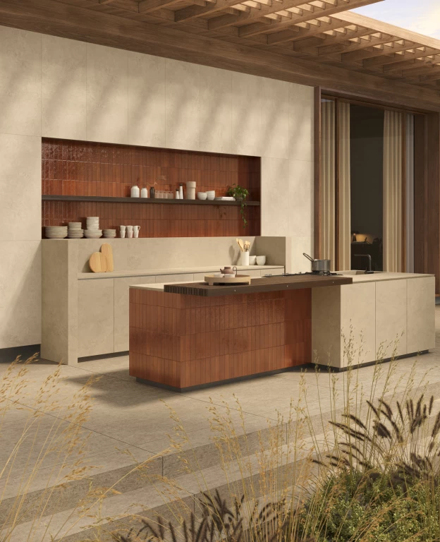 Vista laterale della cucina con top e ante in Boost Hux Dune, dove le spatolature delicate si accostano alle nuance terracotta della nicchia.