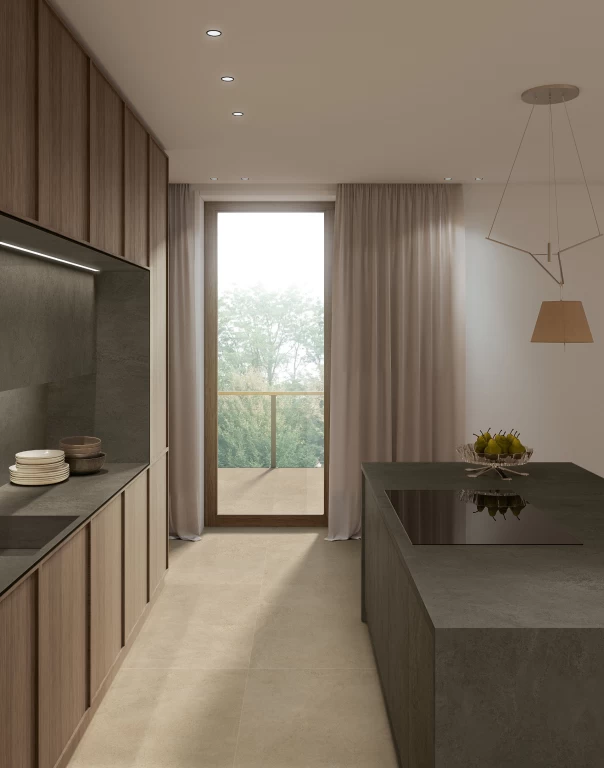 Cucina lineare con isola, piano di lavoro e schienale in gres porcellanato Boost Hux Moka, illuminata dalla luce naturale della vetrata.