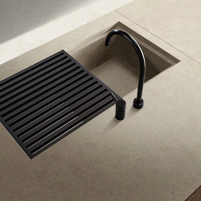 Close-up of the integrated sink within the Boost Vision Camel worktop, complemented by a contrasting black faucet.