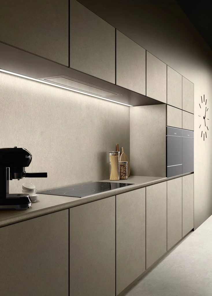 Material and texture composition combining a Boost Vision Camel porcelain worktop with wooden cutting boards and matte black fittings.