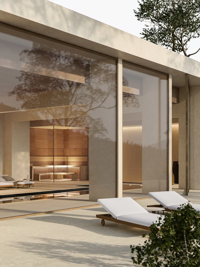 Vista esterna dell'area relax con vetrate affacciate sul giardino e interni rivestiti in gres effetto marmo Breccia Cream, per uno stile elegante e luminoso