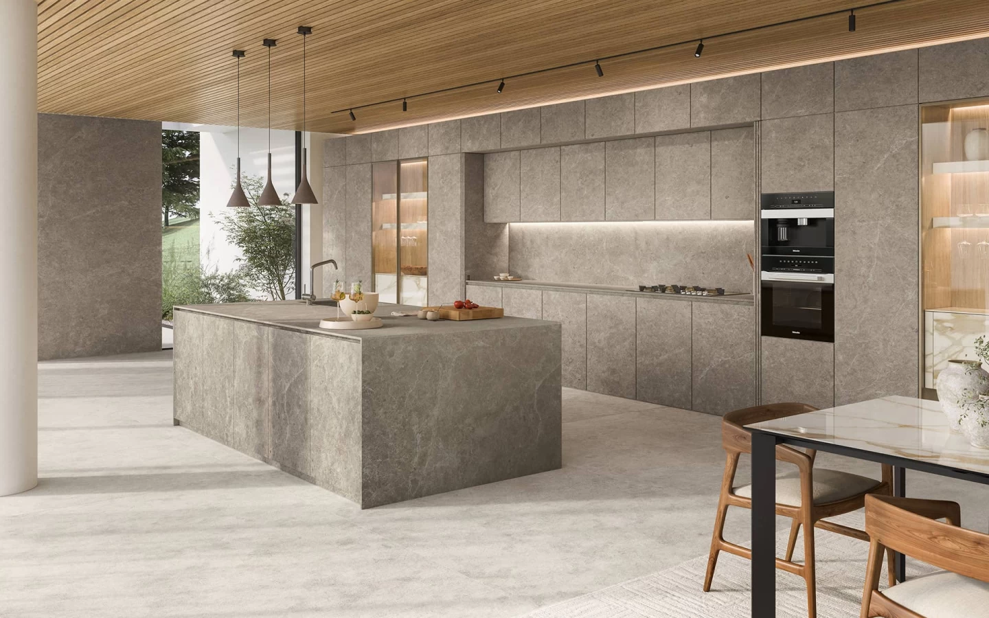 Modern kitchen with a central island clad in Nyra Mist stone-look porcelain by Atlas Plan, featuring soft gray tones and delicate white veining.