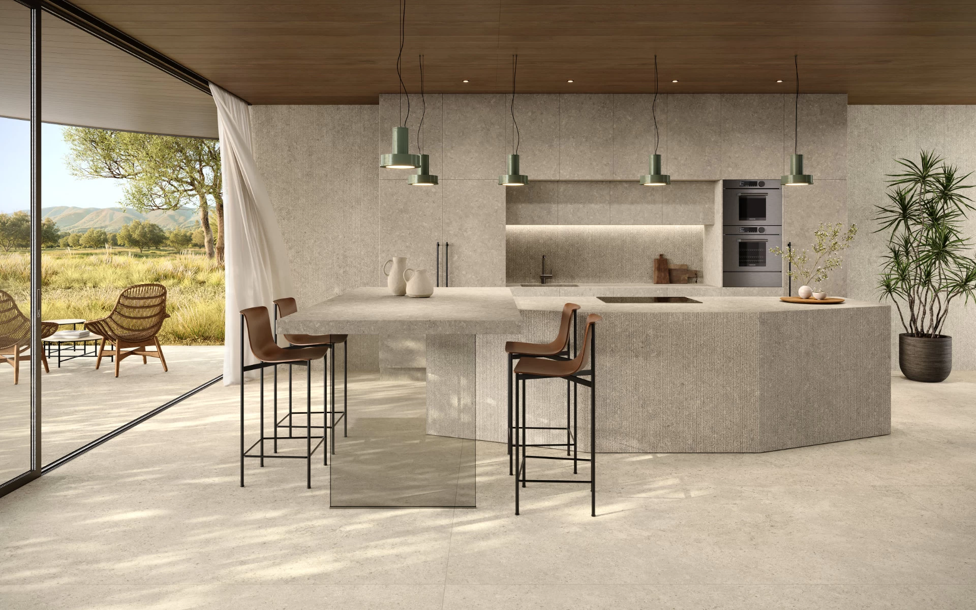 Cucina con isola sfaccettata, piano di lavoro e pareti in gres effetto pietra Nyra Utopia Comet di Atlas Plan, con soffitto in legno e vista sul verde.