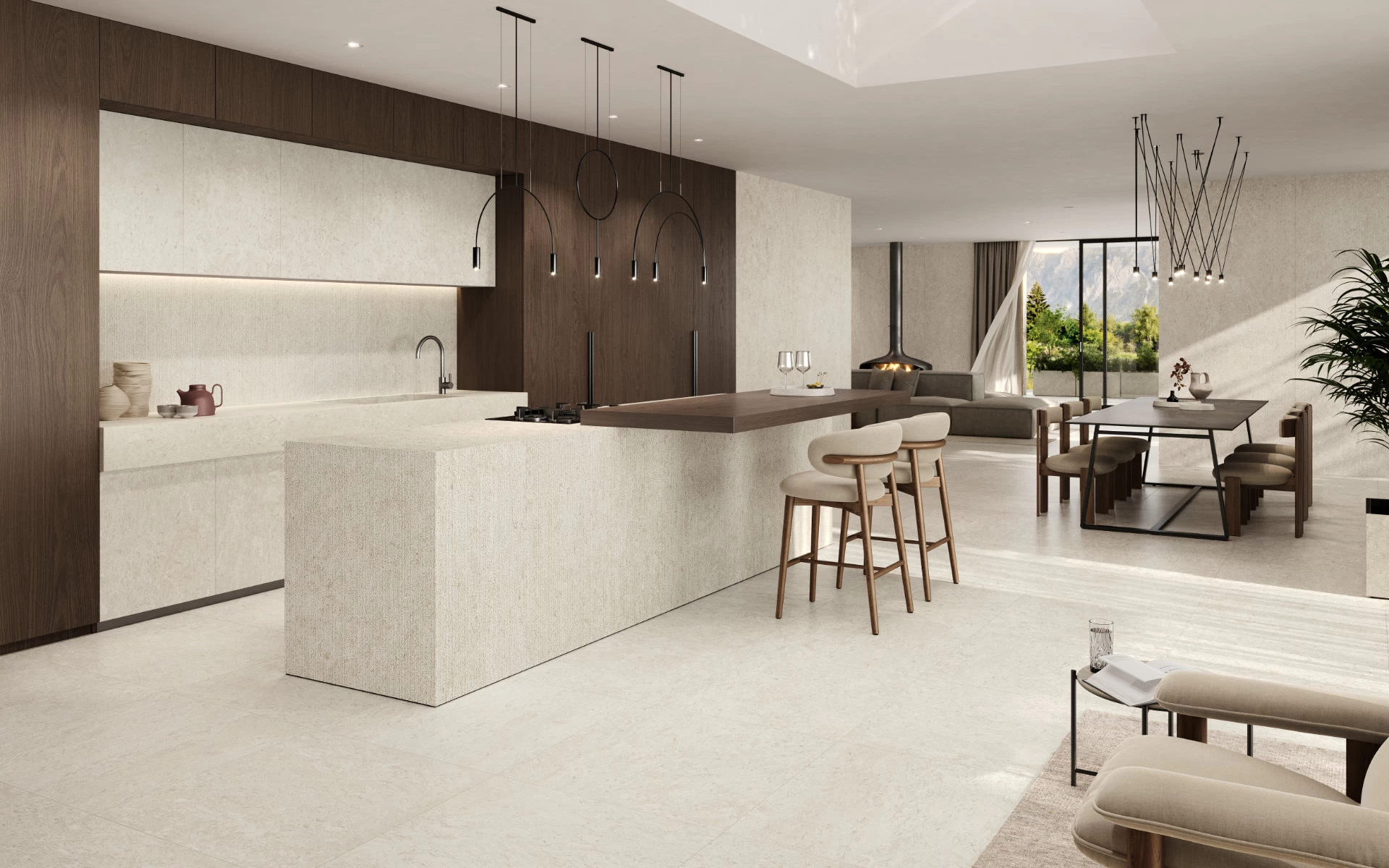 Cucina open space con isola monolitica, ante e pavimento in gres effetto pietra Nyra Utopia Reef di Atlas Plan, in contrasto con le colonne in legno scuro.