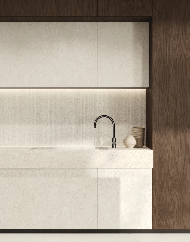 Dettaglio della cucina con top, lavello, schienale e ante in Nyra Utopia Reef, incorniciati dal legno scuro per un ambiente elegante e luminoso.