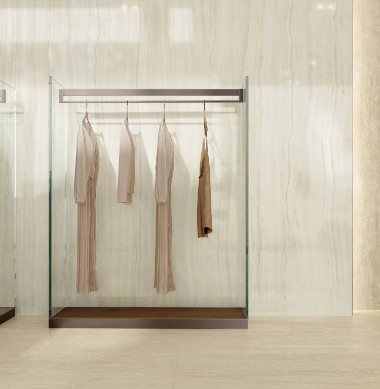 Detailansicht einer Wand in Onyx Ivory mit zarten Maserungen, akzentuiert durch Glas- und Metallaufhängungen für einen eleganten, modernen Effekt.