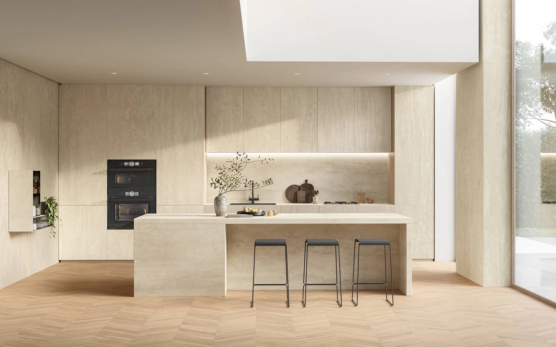 Modern kitchen with a central island clad in Travertino Navona White marble-effect porcelain stoneware by Atlas Plan, featuring warm tones and refined design.