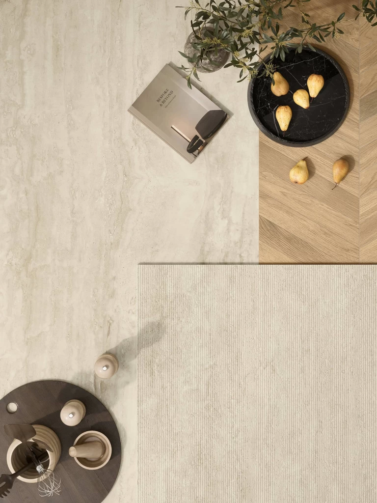 Flat lay composition with material samples, design magazines and a Travertino Navona White surface, highlighting the versatility of Atlas Plan surfaces.