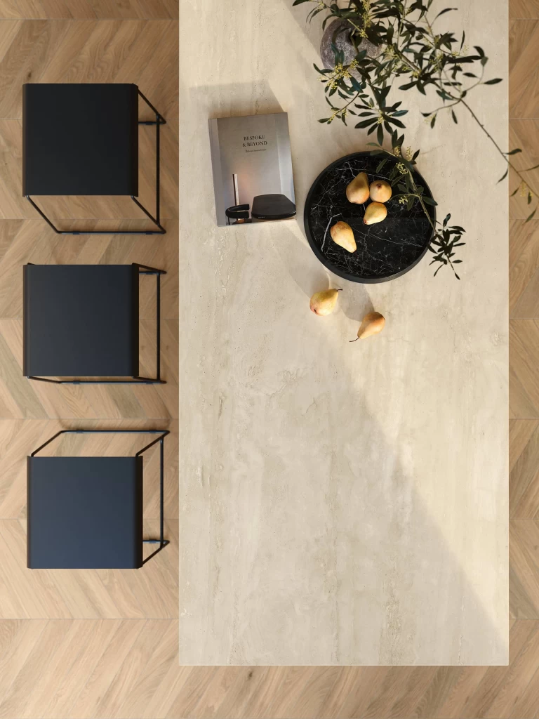 Top view detail of the Travertino Navona White porcelain stoneware kitchen surface with tone-on-tone veining and a decorative composition with fruit and accessories.