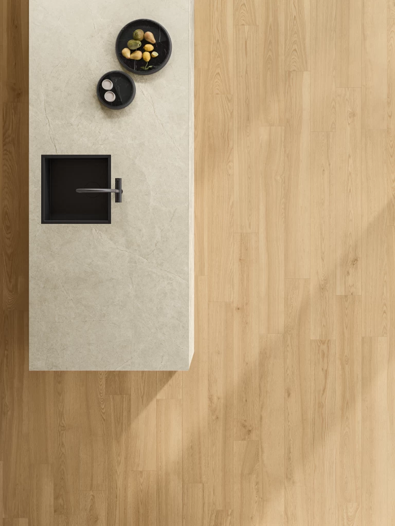 Kitchen island with top and side clad in Vanilla White porcelain stoneware, with flush-mounted black sink and mixer tap.