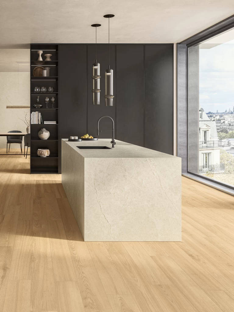 Kitchen with island in Vanilla White marble-effect porcelain facing a large window overlooking the city rooftops.