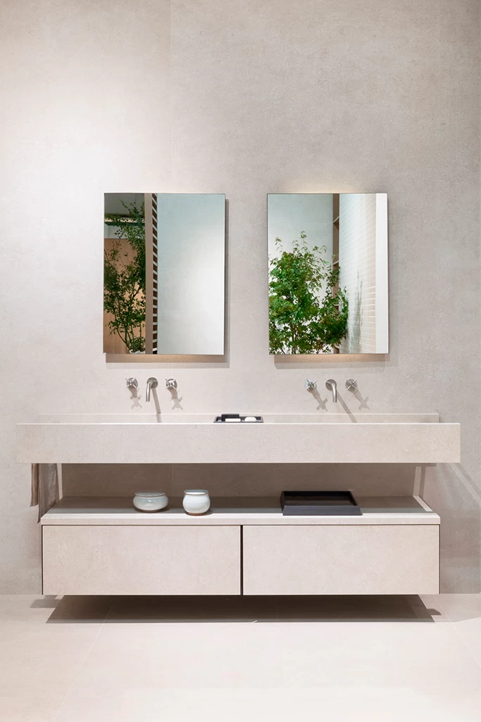 Элегантное пространство ванной комнаты на стенде Atlas Plan на Cersaie 2025 с крупноформатными плитами из керамогранита в изысканной нейтральной отделке, отражающее концепцию One Space гармонии и функциональности.