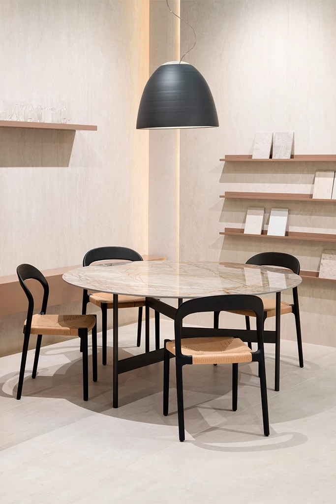 Современная обеденная зона на стенде Atlas Plan на Cersaie 2025 с столом из керамогранитных плит и изысканными отделками, отражающая инновационный подход бренда к дизайну интерьеров.