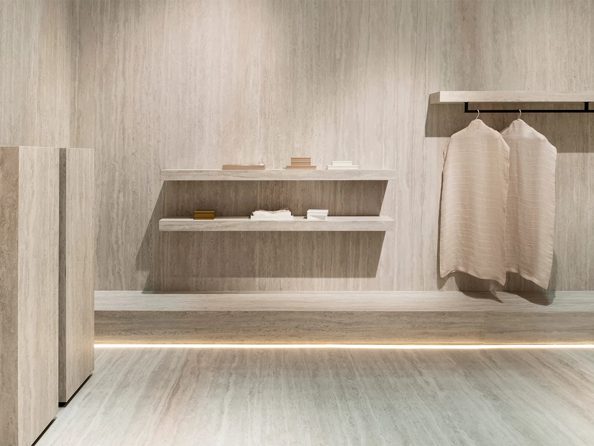 Изысканное интерьерное пространство на стенде Atlas Plan на Cersaie 2025 с текстурированными плитами из керамогранита и полками, иллюстрирующее исследование материалов и устойчивое видение бренда.