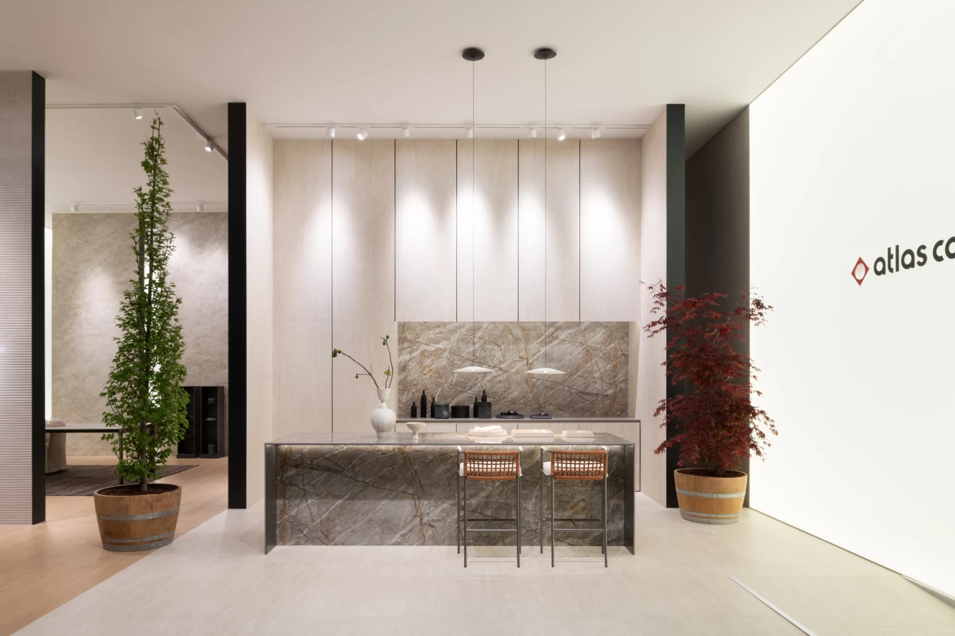 Atlas Concorde stand at Salone del Mobile with kitchen in Atlas Plan porcelain slabs and decorative plants