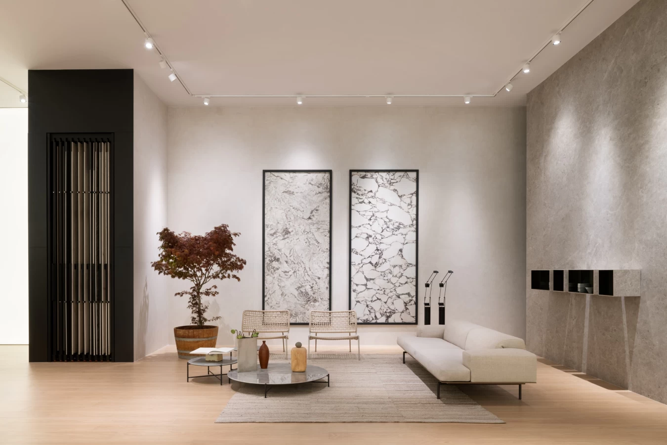 Living area with Atlas Plan porcelain surfaces, coffee tables and marble-effect wall cladding