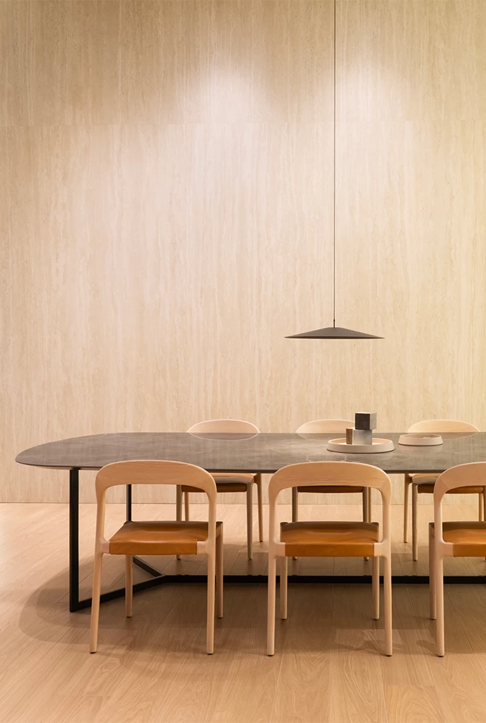 Dining room with table in Atlas Plan porcelain slabs and contemporary wooden chairs