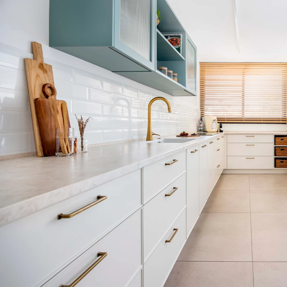 View of a country chic kitchen with Atlas Plan's Cream Prestige stoneware countertop, which combines elegance and functionality with natural veining.