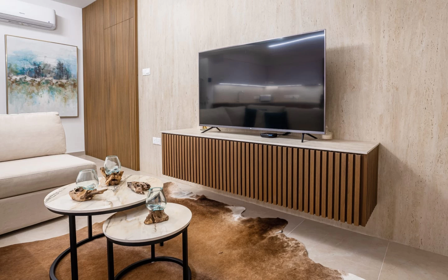 Living room wall cladding with large travertine look stoneware slabs by Atlas Plan
