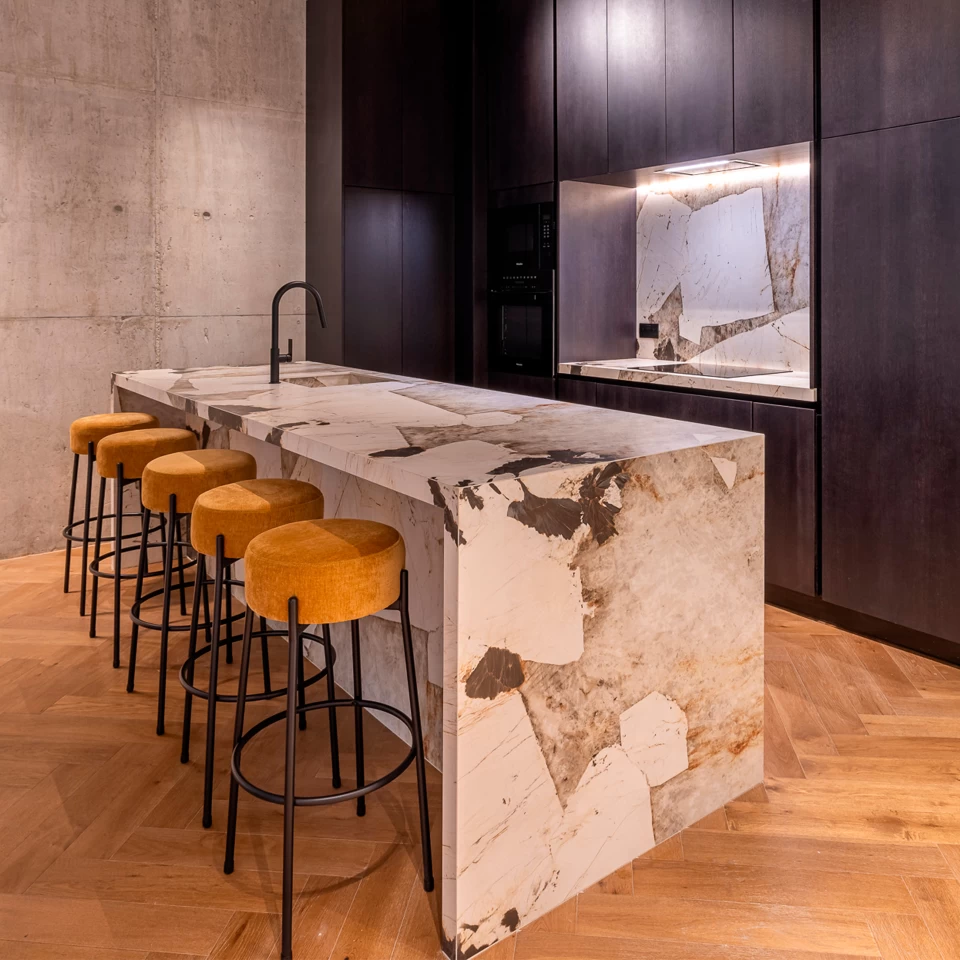 Kitchen with decorative forms and island covered with Desert Soul marble