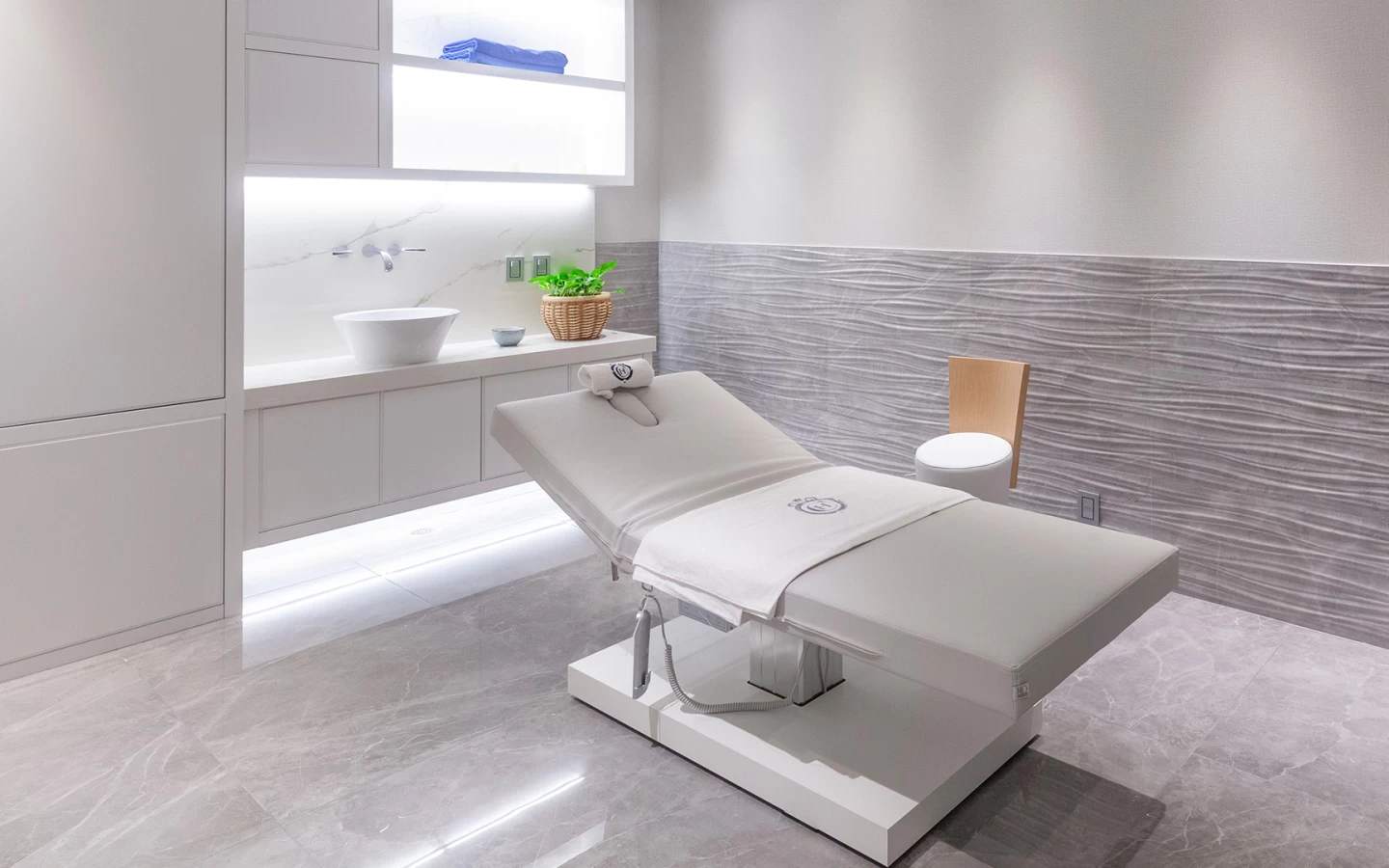 Massage room with walls clad in Atlas Plan marble-effect porcelain stoneware.