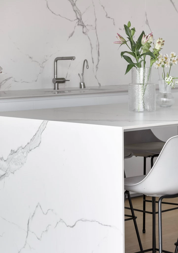 Nahaufnahme der Küchenrückwand und Arbeitsplatte aus dem Feinsteinzeug Calacatta Extra von Atlas Plan, das die Schönheit des Marmors auf zeitgemäß funktionelle Weise unterstreicht