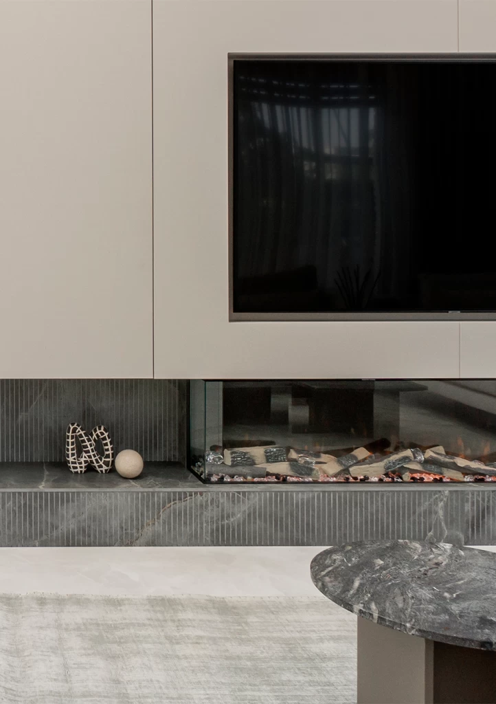 Vista de un espectacular salón con escalera volada y pared de TV en Fior di Bosco, que da personalidad y profundidad al espacio.